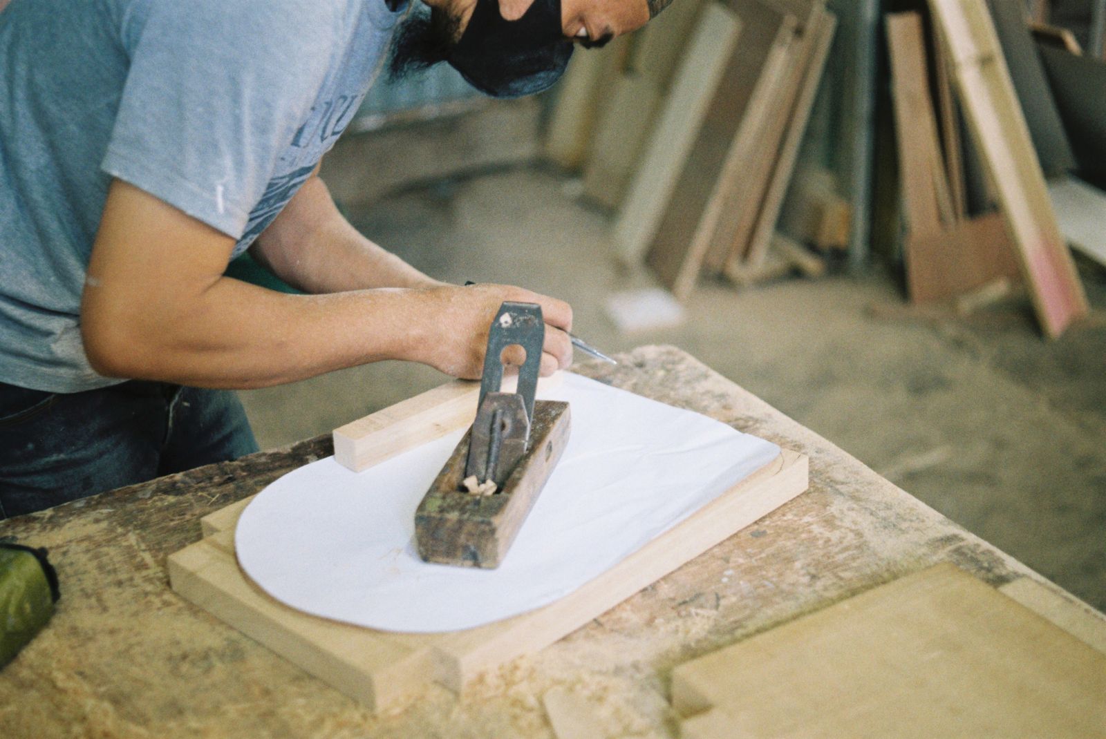 A carpenter smoothing a timber board with a hand plane