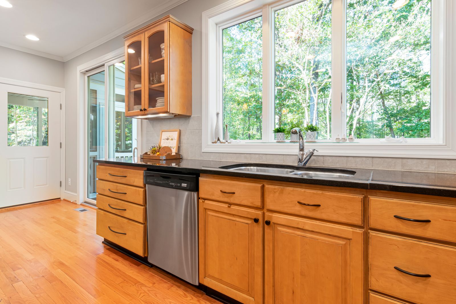 A bright kitchen with honey-toned timber cupboards under a row of windows